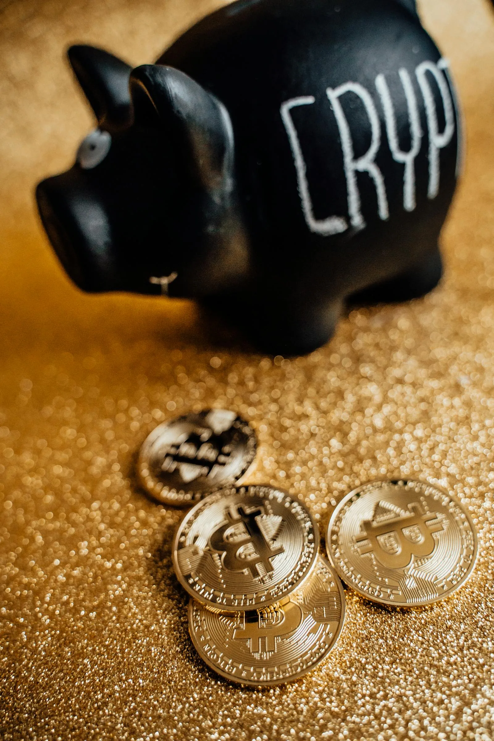 Heo đất tiết kiệm màu đen ghi chữ CRYPTO và các đồng Bitcoin vàng trên nền vàng nhũ, minh họa cách giảm gas fee crypto