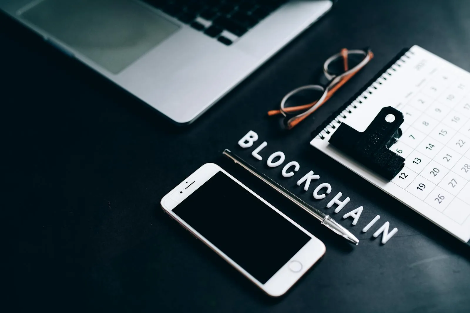 Chữ BLOCKCHAIN smartphone bút lịch trên bàn tượng trưng cho Bitcoin Ethereum node thống kê