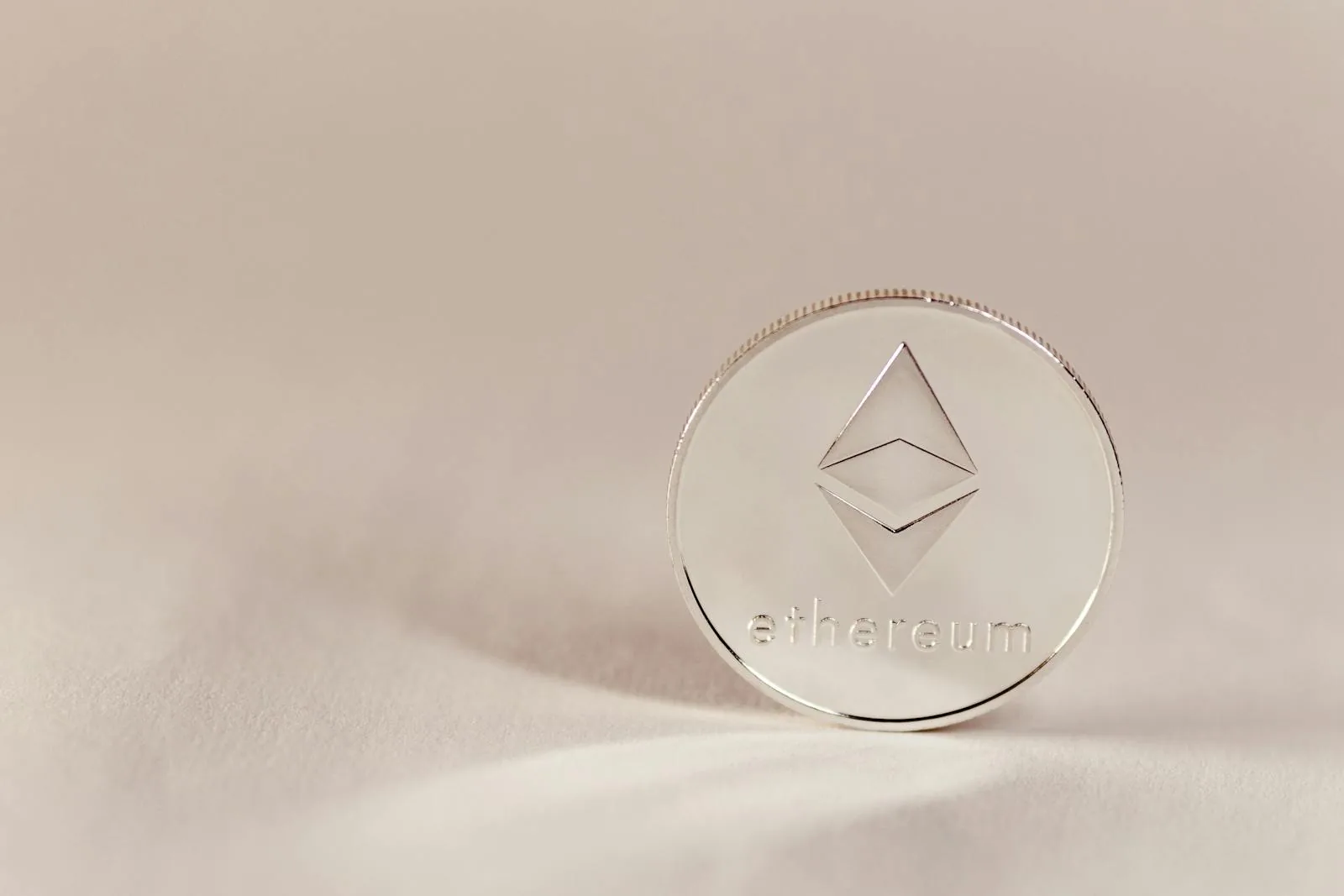 Đồng Ethereum bạc nền kem tượng trưng cho liquid staking Lido stETH Rocket Pool