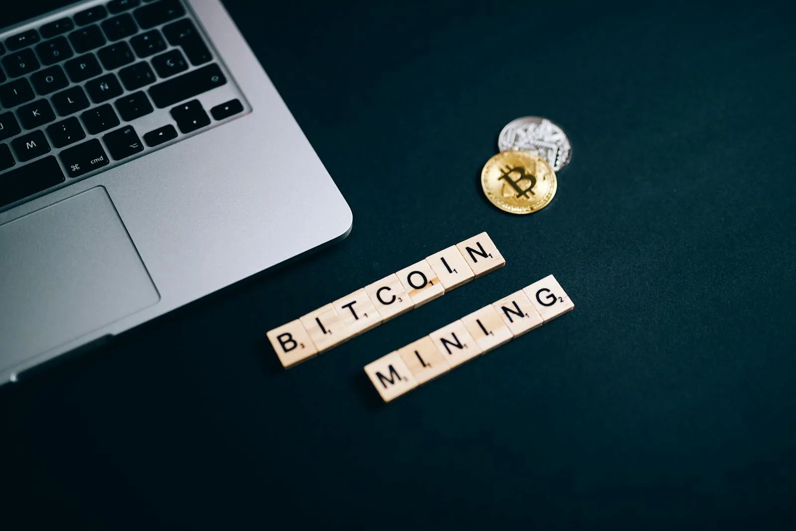 Chữ Bitcoin Mining scrabble bên laptop và đồng coin tượng trưng cho SHA-256 hash puzzle