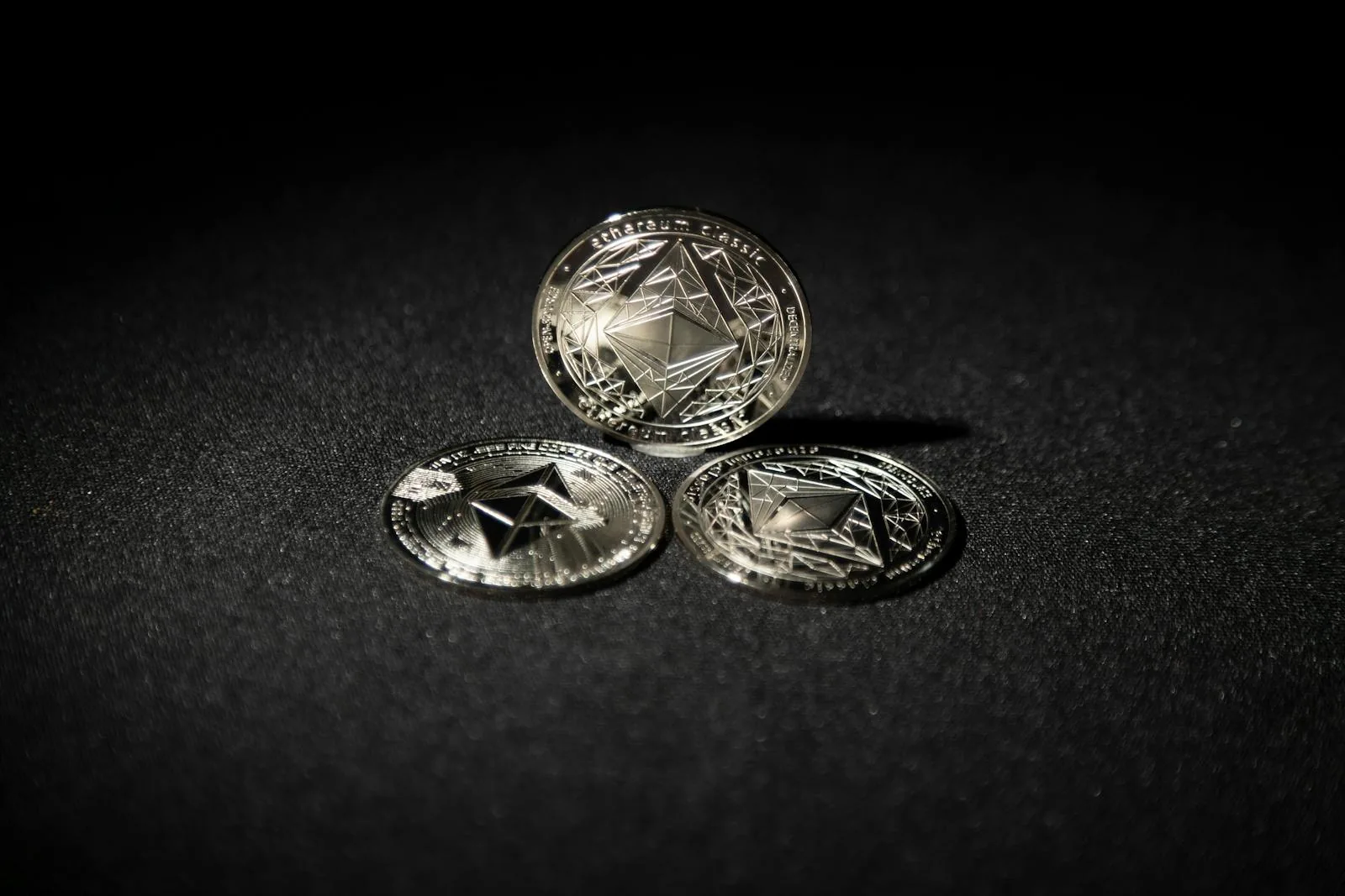 Ba đồng Ethereum Classic bạc xếp trên nền tối tượng trưng cho wrapped token và liquid staking